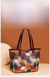 Detail of colorful geometric patchwork tote bag with crocodile texture and gold hardware