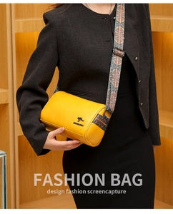 Detail of yellow barrel crossbody bag with patterned strap and metal kangaroo logo