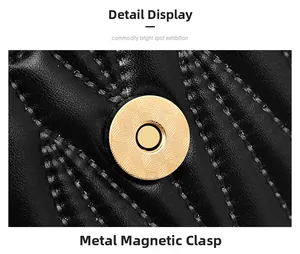 Close-up of golden circular magnetic buckle on black quilted leather bag with grid pattern