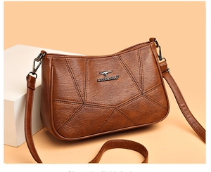 Detail of brown leather handbag with geometric stitching and metal kangaroo logo emblem