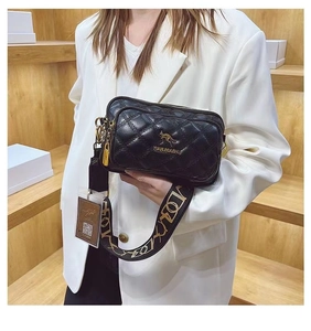 Close-up of black quilted crossbody bag featuring golden logo and stylish wide strap