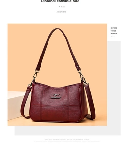 Close-up of wine red leather bag featuring a gold kangaroo logo and lychee texture