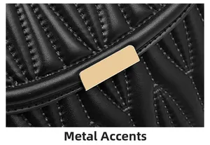 Detailed macro view of black quilted leather shoulder bag with gold chevron hardware buckle