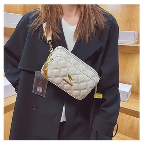Close-up of white quilted crossbody bag featuring a golden kangaroo logo and chain detail
