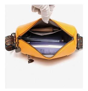 Detail of yellow PU leather crossbody bag with spacious main compartment and jacquard strap