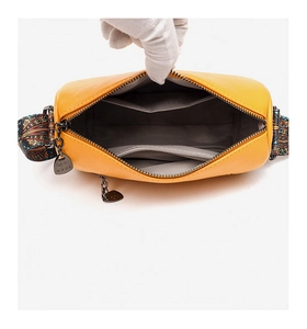 Detail view of yellow PU leather bag interior with main compartment and zipper pocket