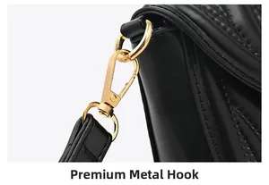Detail of textured golden metal hook and quilted PU leather strap on a black bag