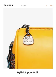 Detail of yellow leather bag featuring gunmetal zipper pull with kangaroo logo