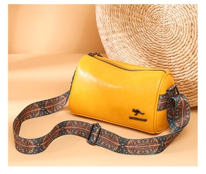 Detail view of yellow PU leather cylinder bag with vintage ethnic pattern wide strap