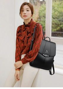 Detail view of black pebble leather backpack with decorative silver flower metal buckle