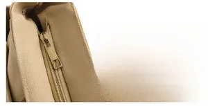 Détail d'une fermeture éclair en bronze vintage sur un sac de voyage en toile beige