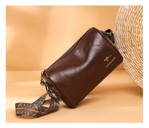 Detailed macro view of the brown leather cylinder bag with colorful geometric strap