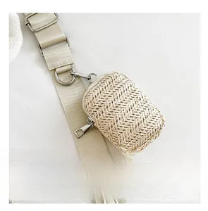 Macro detail of beige straw weave texture and silver zipper on mini crossbody bag