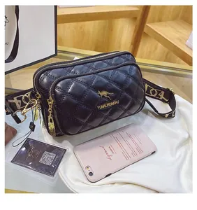 Detail of black quilted leather crossbody bag with gold logo and wide patterned strap