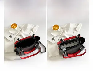 Detailed view of black litchi pattern tote bag with red interior and spacious compartments