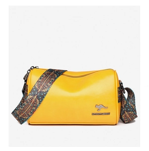 Detail of yellow cylinder bag featuring a metal kangaroo logo and colorful woven strap