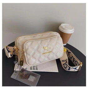 Close-up of beige quilted crossbody bag with golden kangaroo logo and stylish wide strap