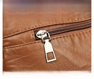 Detail of caramel lychee grain leather crossbody bag with metallic zipper and hardware