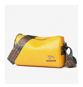 Macro detail of yellow PU leather barrel bag with ethnic pattern wide strap and logo