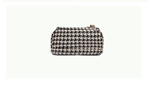 Detailed close-up of houndstooth fabric canvas bag with metal zipper and leather puller