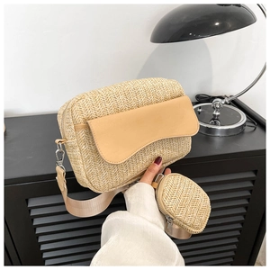 Detail of woven straw crossbody bag featuring leather trim and a small round pouch