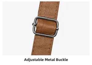 Detail of adjustable silver metal buckle on brown pebbled leather shoulder strap