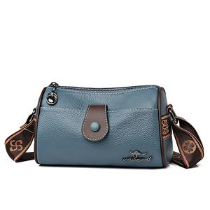 Sac bandoulière cylindrique en cuir bleu avec texture et large sangle à motifs
