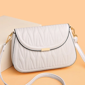 Elegant beige quilted PU leather crossbody bag with gold buckle on a geometric stand