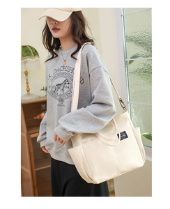 Détail d'un grand sac cabas en toile crème avec bandoulière réglable et poche latérale