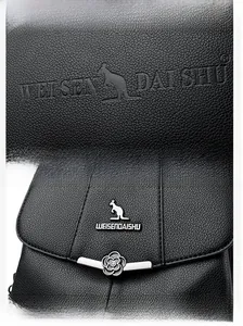 Detailed shot of black litchi grain leather and silver floral metal clasp on a backpack