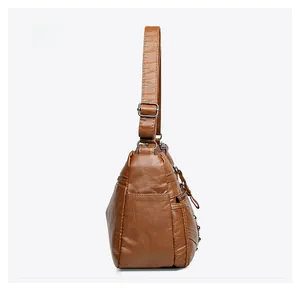 Side view of brown soft leather crossbody bag with multiple pockets and silver buckles