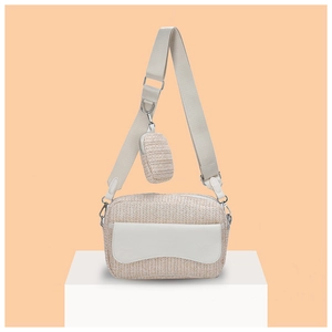 Detail of beige straw woven camera bag with wide strap and matching round coin purse