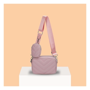 Detail der rosafarbenen Stepptasche mit verstellbarem Gurt und abnehmbarer kleiner Börse