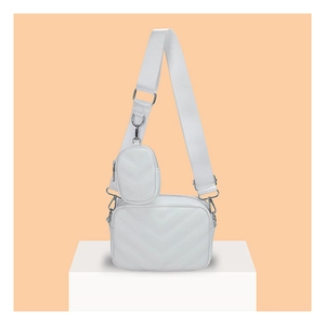 Detailansicht der weißen Stepptasche mit passender Mini-Tasche am breiten Trageriemen