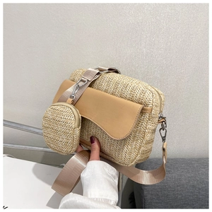 Detail of woven straw crossbody bag with brown leather flap and small coin pouch
