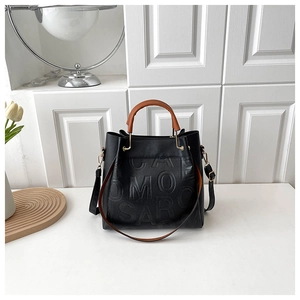 Detail of black pebbled leather bucket bag with embossed CAMOSAR letters and gold hardware
