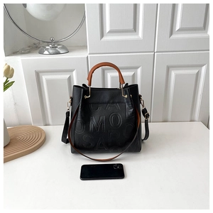 Detail of black embossed leather tote with iPhone for size comparison and large capacity