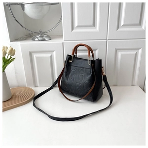 Detail showing high-quality black litchi grain leather texture and embossed lettering
