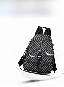Détail d'un sac à dos en nylon noir avec imprimé géométrique et fermetures éclair dorées