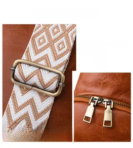 Detail of retro leather chest bag with woven strap and bronze hardware accents