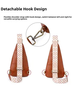 Detail of detachable metal hook and D-ring on brown leather sling bag for reversible carrying