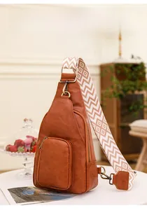 Close-up of vintage brown leather chest bag with patterned ethnic style shoulder strap