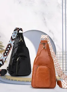 Detail view of vintage soft leather sling bags with colorful woven straps on a stand
