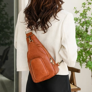 Caramel brown leather sling bag with ethnic woven strap and retro hardware detail