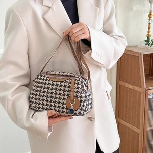 Fashion houndstooth canvas shoulder bag with brown leather strap held by a model
