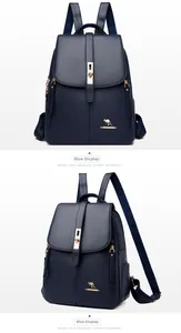 Detail view of dark blue leather backpack featuring pebble texture and gold metal accents