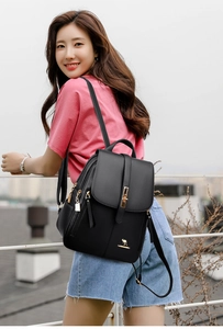 Close-up of textured leather backpack with gold buckle and kangaroo logo branding