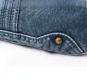 Detail einer dunkelblauen Umhängetasche aus Kunstleder mit Vintage-Niete und geprägter Textur