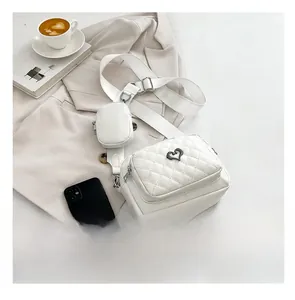 Quilted white crossbody bag detail with heart charm and matching round coin purse