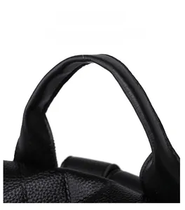 Close-up of the reinforced round handle on a black pebbled leather backpack for women